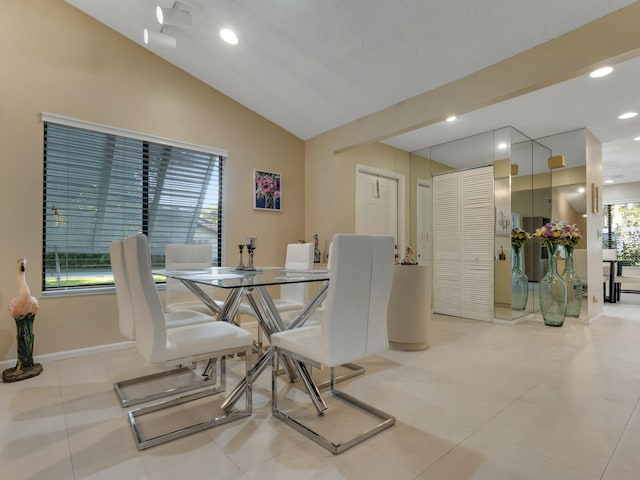 tiled dining room featuring lofted ceiling