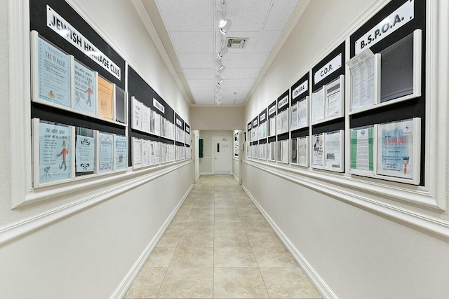 hallway with track lighting, light tile patterned flooring, a mail area, and crown molding