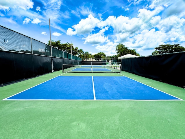 view of tennis court with basketball hoop