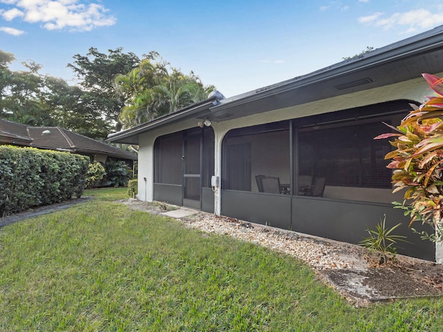 view of side of home featuring a yard and a sunroom