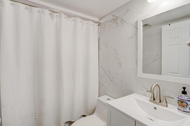 bathroom featuring walk in shower, vanity, and toilet