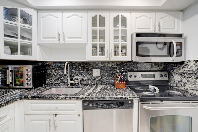 kitchen with white cabinets, stainless steel appliances, tasteful backsplash, and sink