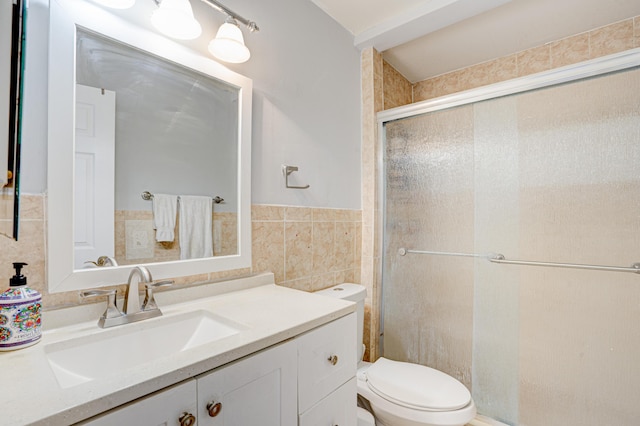 bathroom featuring tile walls, an enclosed shower, toilet, and vanity