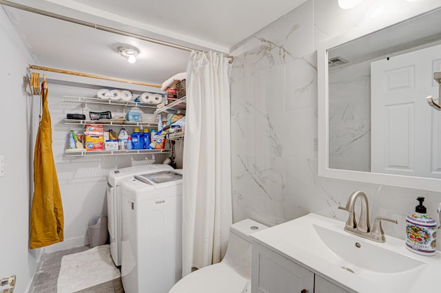 bathroom featuring toilet, washing machine and dryer, a shower with shower curtain, and vanity