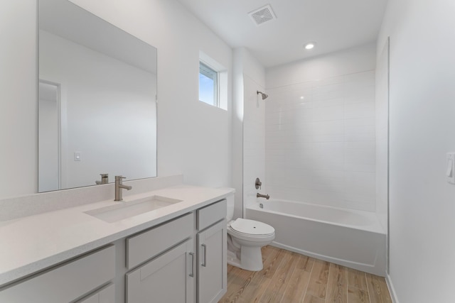 full bathroom with shower / tub combination, vanity, wood-type flooring, and toilet