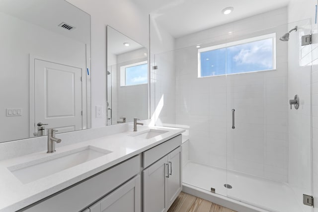 bathroom featuring hardwood / wood-style flooring, vanity, and walk in shower