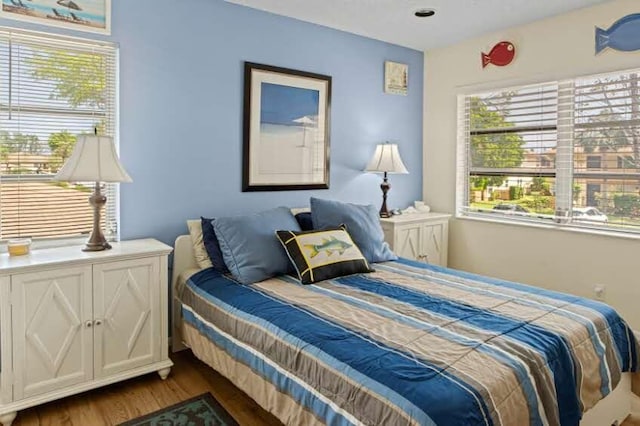 bedroom with hardwood / wood-style flooring and multiple windows