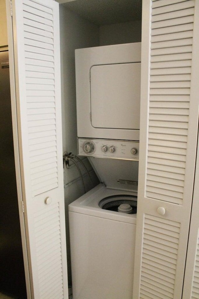 clothes washing area featuring stacked washer / dryer