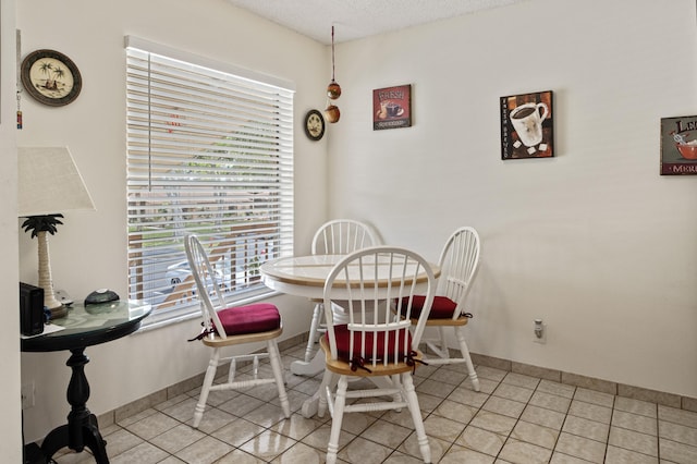 tiled dining area with a textured ceiling