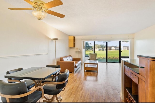 dining area with ceiling fan, light hardwood / wood-style floors, and a textured ceiling