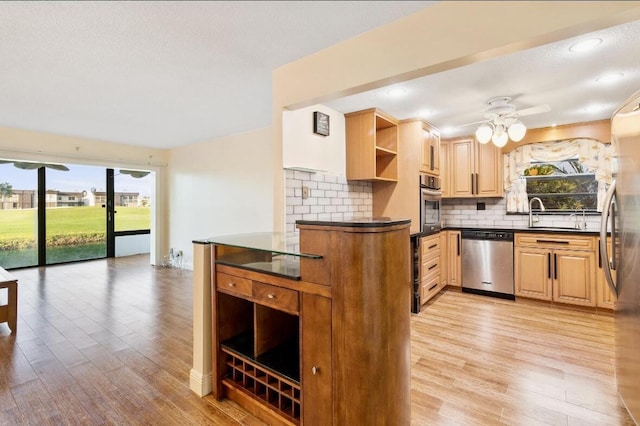 kitchen featuring sink, ceiling fan, tasteful backsplash, kitchen peninsula, and stainless steel appliances