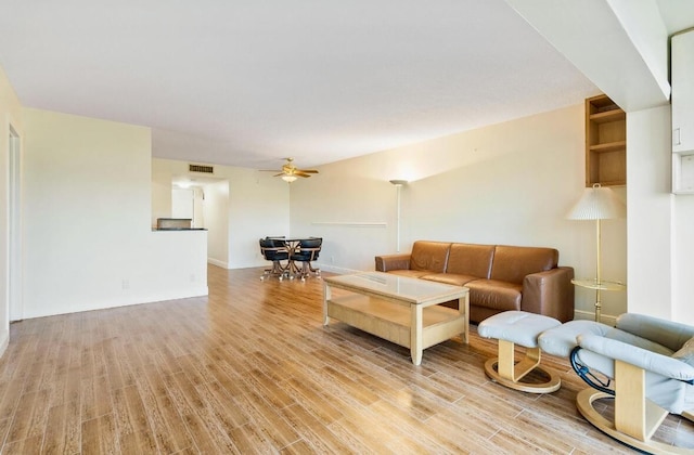 living room featuring ceiling fan and light hardwood / wood-style flooring