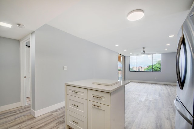 kitchen with ceiling fan, stainless steel fridge, light hardwood / wood-style floors, and white cabinetry