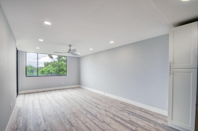 empty room with ceiling fan and light wood-type flooring