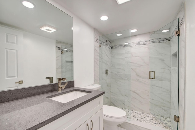 bathroom with toilet, a shower with shower door, and vanity