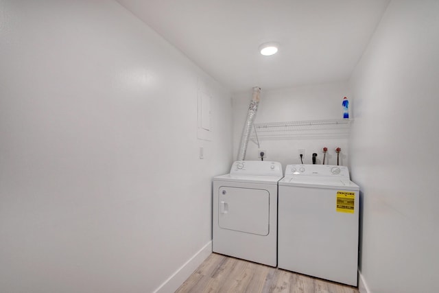 laundry room featuring separate washer and dryer and light hardwood / wood-style floors