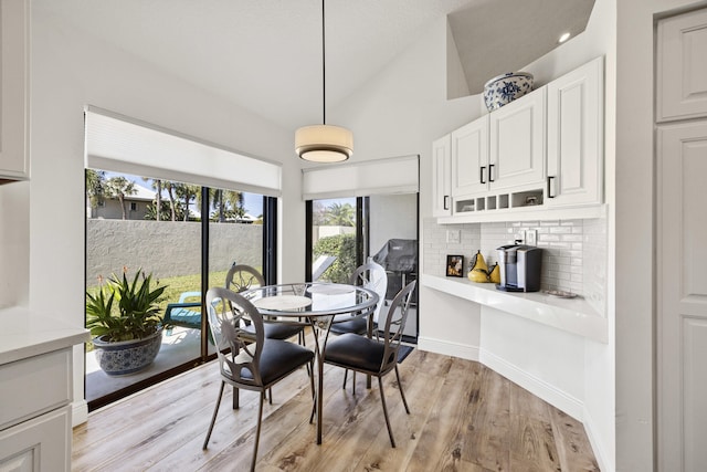 dining area featuring a wealth of natural light, lofted ceiling, and light hardwood / wood-style floors