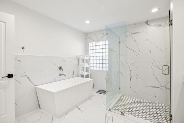 bathroom with tile walls and shower with separate bathtub