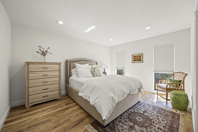 bedroom with wood-type flooring and a textured ceiling