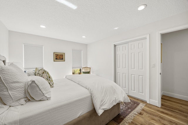 bedroom featuring a textured ceiling, a closet, and light hardwood / wood-style flooring