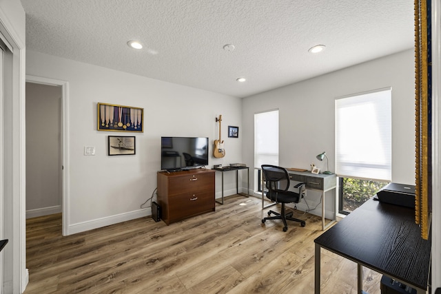 home office with hardwood / wood-style floors and a textured ceiling