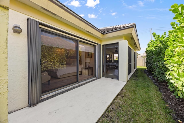 entrance to property with a yard and a patio