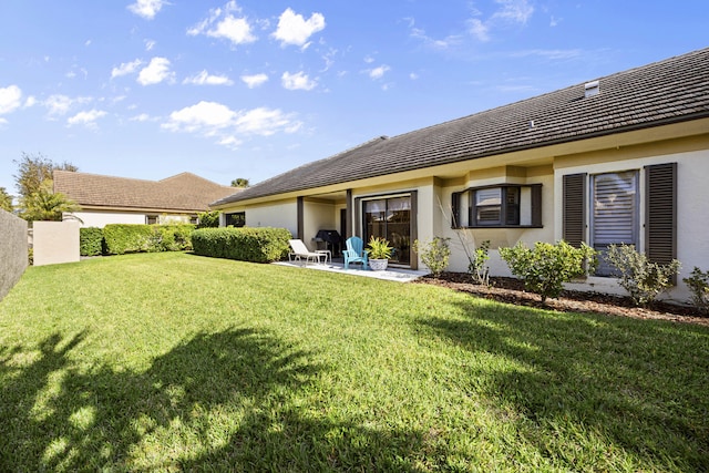 back of property with a patio area and a lawn