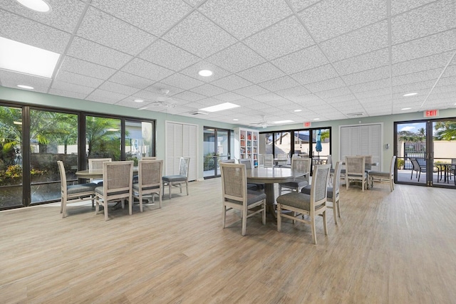 dining space with hardwood / wood-style floors and a paneled ceiling