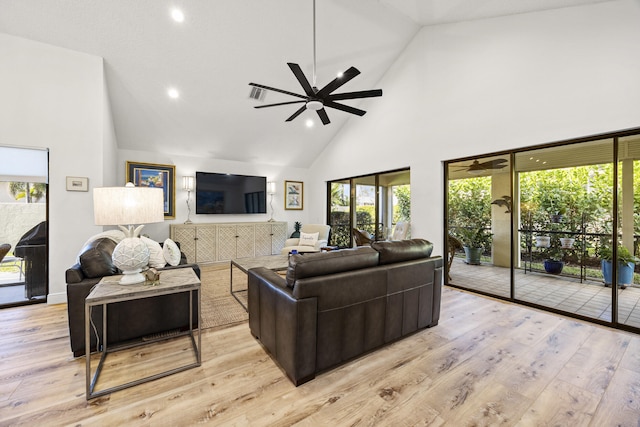 living room featuring ceiling fan, light hardwood / wood-style floors, and high vaulted ceiling