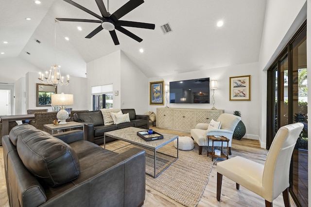 living room with high vaulted ceiling, a wealth of natural light, light hardwood / wood-style flooring, and ceiling fan with notable chandelier