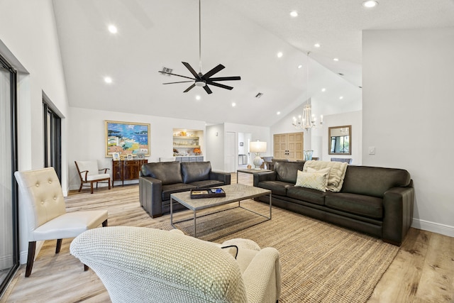 living room with light wood-type flooring, ceiling fan with notable chandelier, high vaulted ceiling, and built in shelves