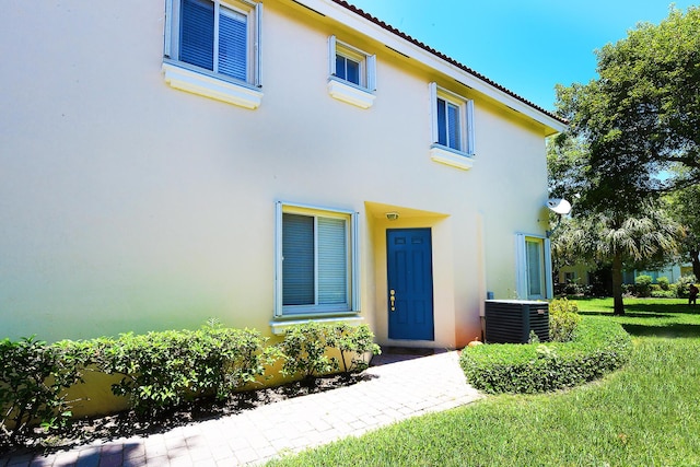 view of front facade featuring cooling unit and a front yard