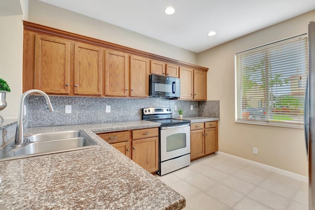 kitchen featuring stainless steel range with electric cooktop, light tile patterned flooring, backsplash, and sink