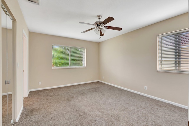 spare room featuring ceiling fan and light colored carpet