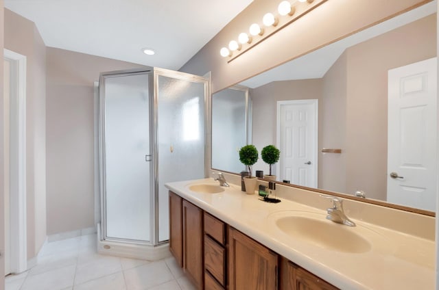 bathroom featuring tile patterned flooring, a shower with shower door, and vanity