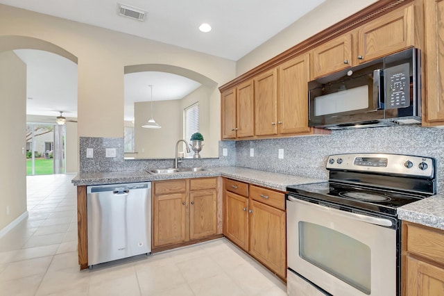 kitchen with light stone countertops, decorative light fixtures, stainless steel appliances, sink, and ceiling fan