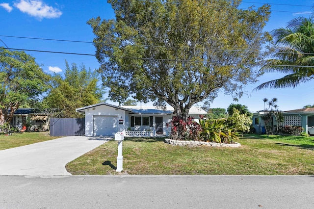 single story home featuring a garage, driveway, and a front lawn