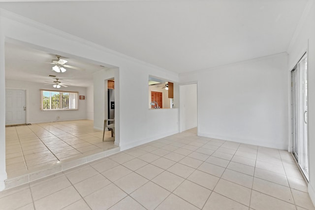 spare room with light tile patterned floors, baseboards, ornamental molding, and ceiling fan