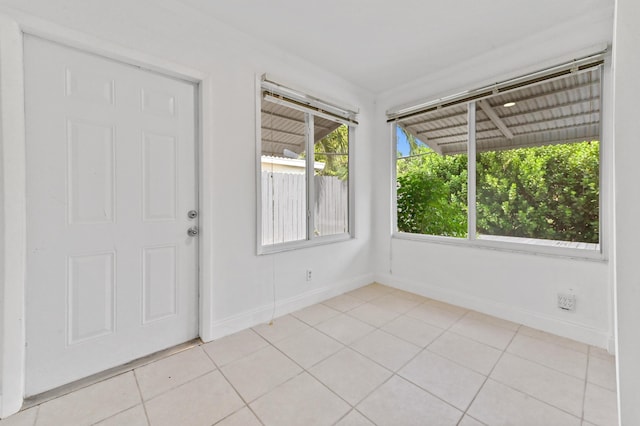 empty room featuring light tile patterned flooring and baseboards