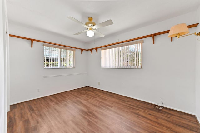 empty room featuring baseboards, a ceiling fan, and wood finished floors