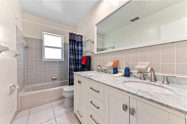 bathroom with toilet, a sink, tile walls, and tile patterned floors