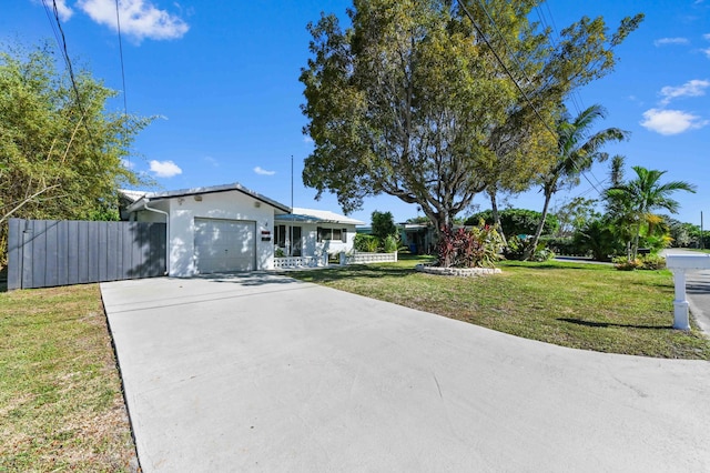 single story home featuring a front lawn, concrete driveway, fence, and an attached garage