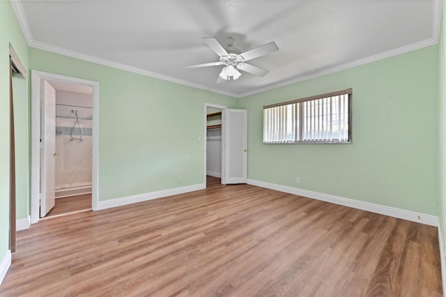 unfurnished bedroom featuring baseboards, light wood-style flooring, and crown molding