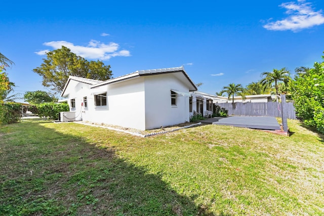 exterior space featuring a fenced backyard, a lawn, and stucco siding