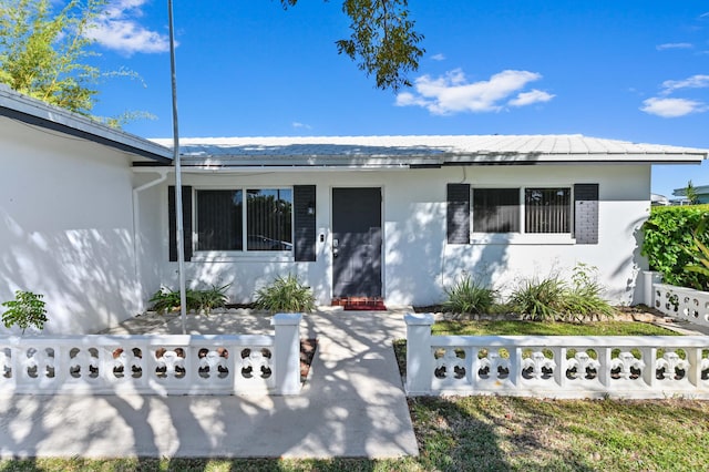 view of front of property featuring a fenced front yard and stucco siding