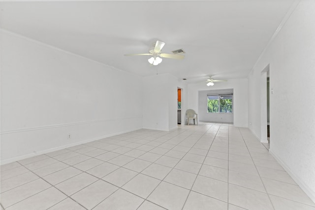 spare room with baseboards, ornamental molding, visible vents, and a ceiling fan