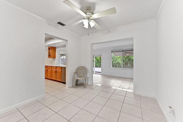 spare room featuring light tile patterned floors, baseboards, visible vents, a ceiling fan, and ornamental molding