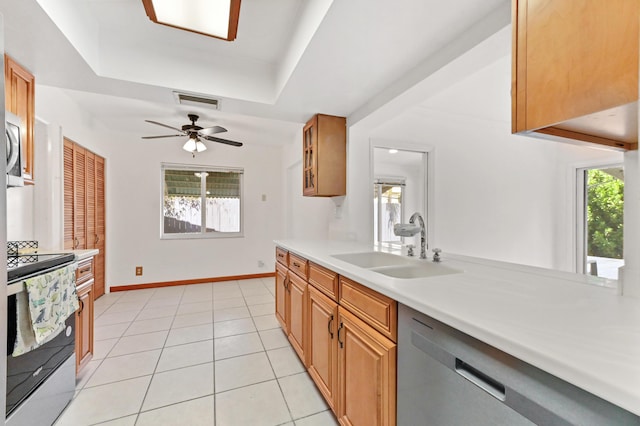 kitchen with light tile patterned floors, stainless steel appliances, a sink, visible vents, and light countertops