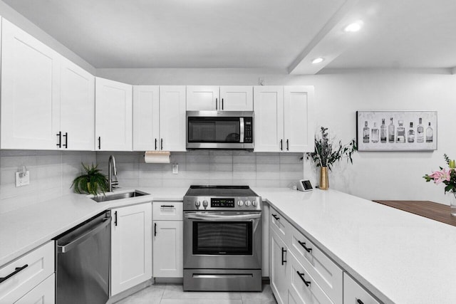 kitchen featuring backsplash, sink, light tile patterned flooring, stainless steel appliances, and white cabinets