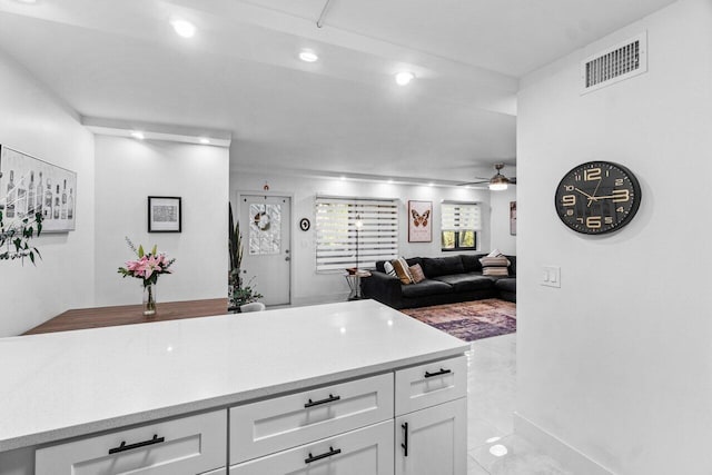 kitchen featuring ceiling fan, light tile patterned floors, and white cabinets